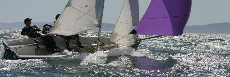 person in blue and white sailboat on body of water during daytime