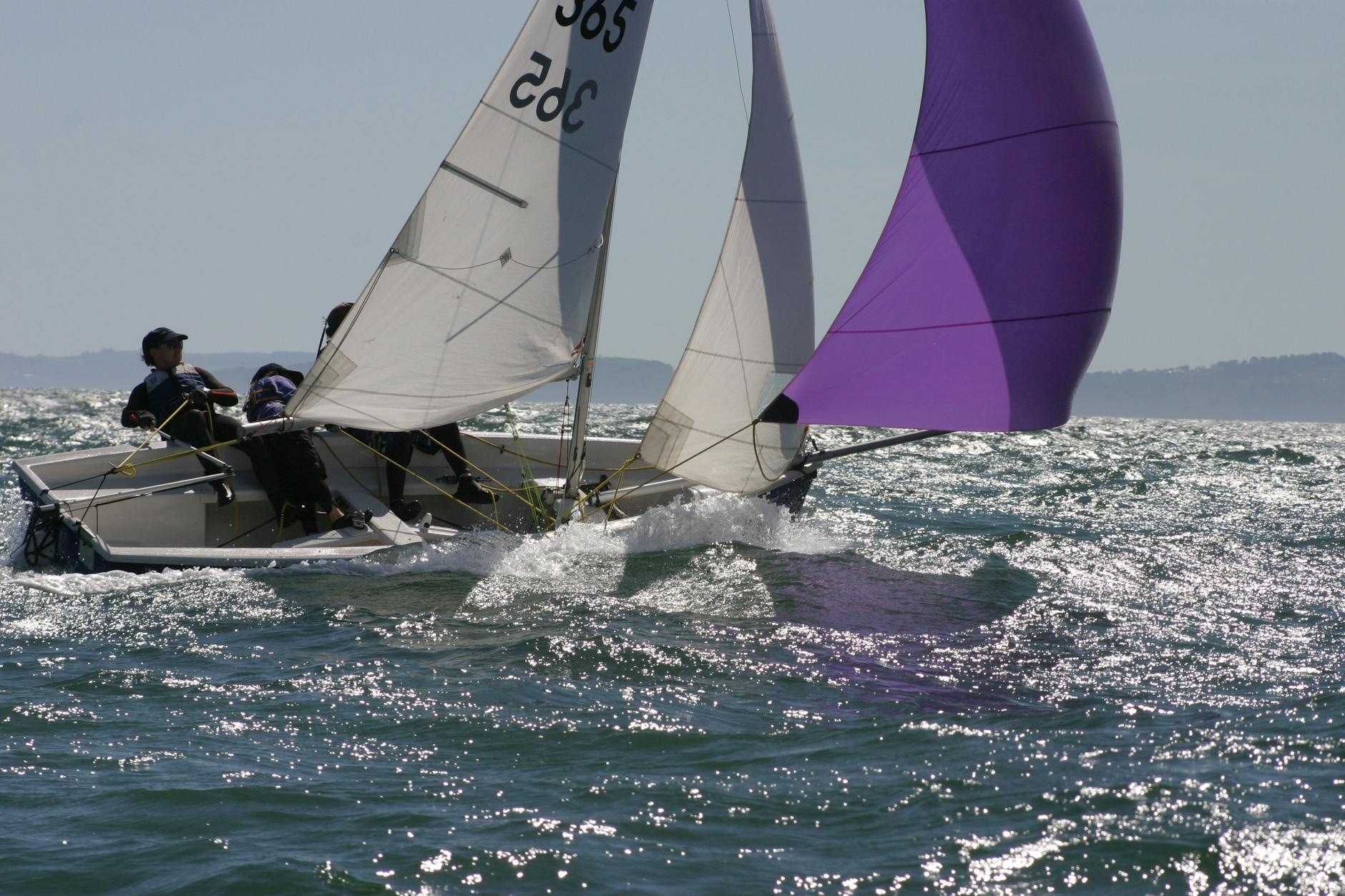 person in blue and white sailboat on body of water during daytime