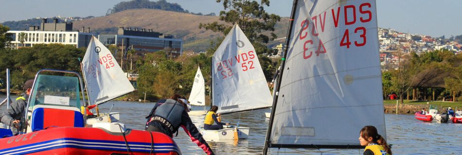 view of people sitting in sailboats on a body of water