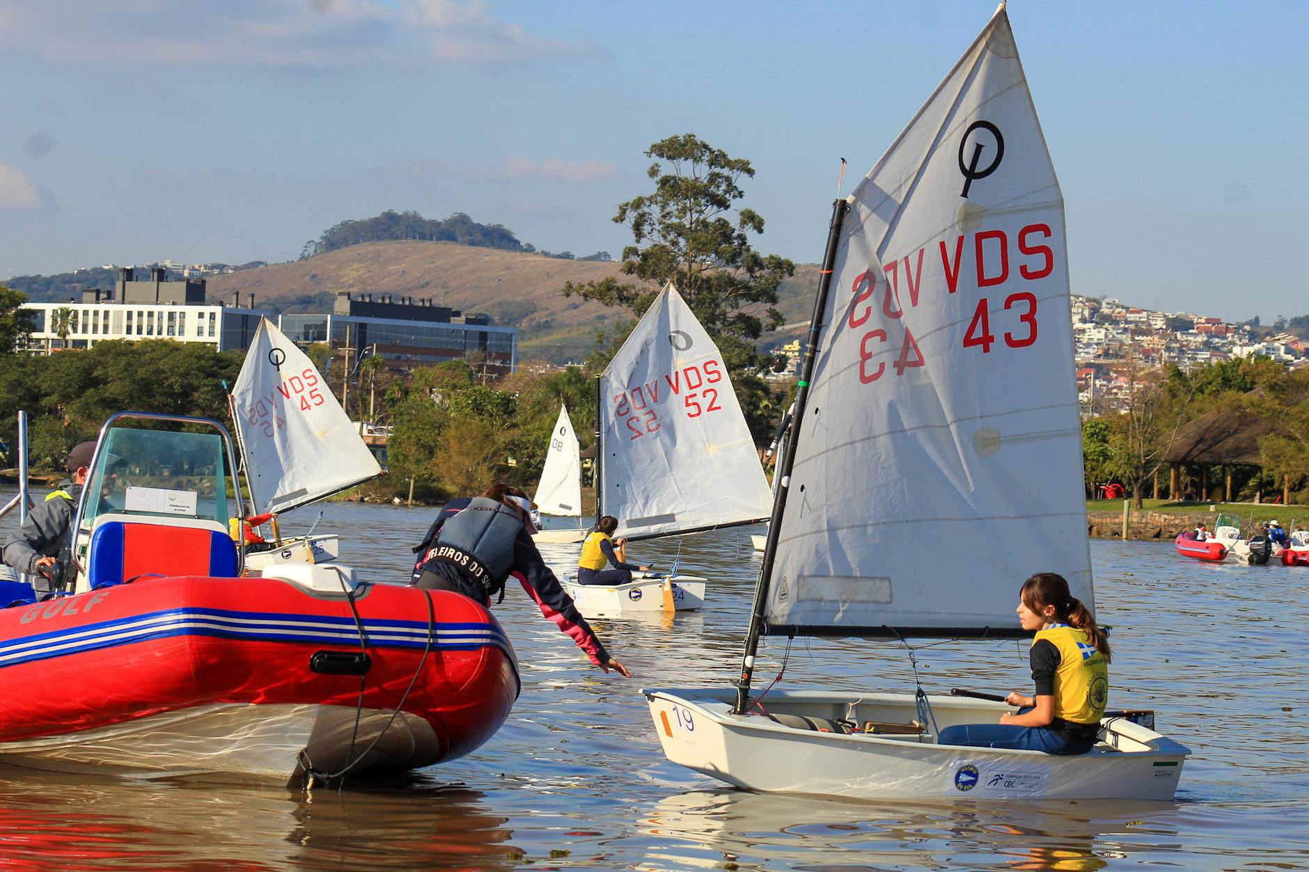 view of people sitting in sailboats on a body of water