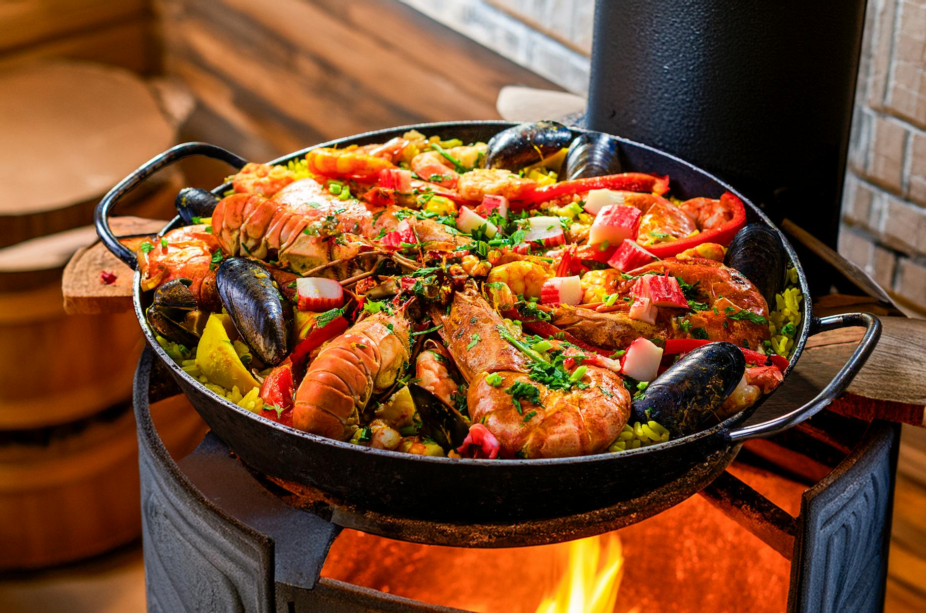 vibrant seafood paella cooking over open flame